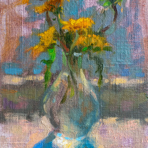 Sunlit dandelions gracefully arranged in a glass vase